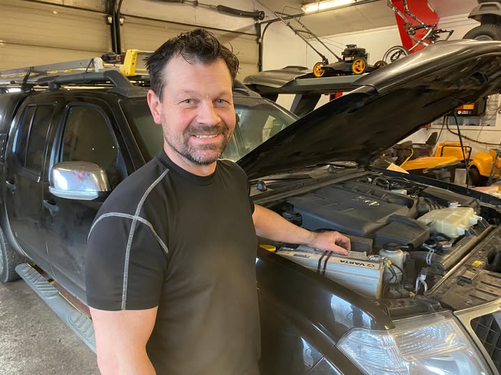 man på bilden står vid en bil